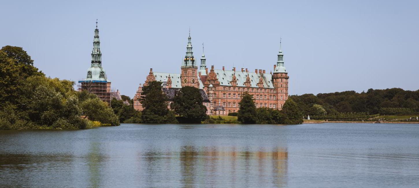  Frederiksborg Schloss mit dem Schlosssee davor, gesehen vom Marktplatz in Hillerød an einem Sommertag.