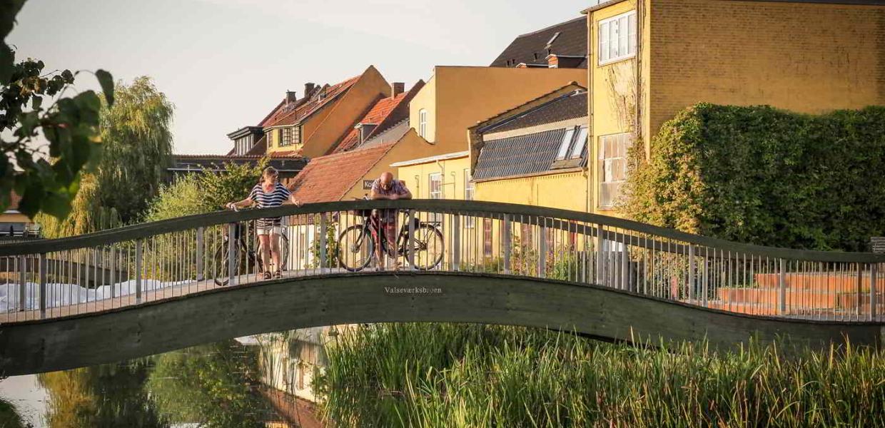 Zwei Radfahrer machen eine Pause auf einer der Brücken über den Kanal in Frederiksværk.