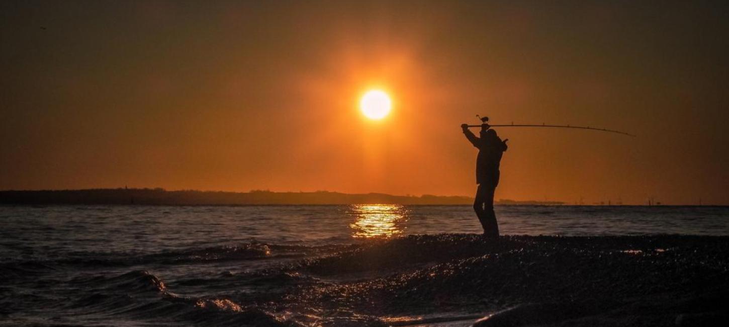 En mand fisker i havet i Nordsjælland ved Øresund på Kronborg Strand