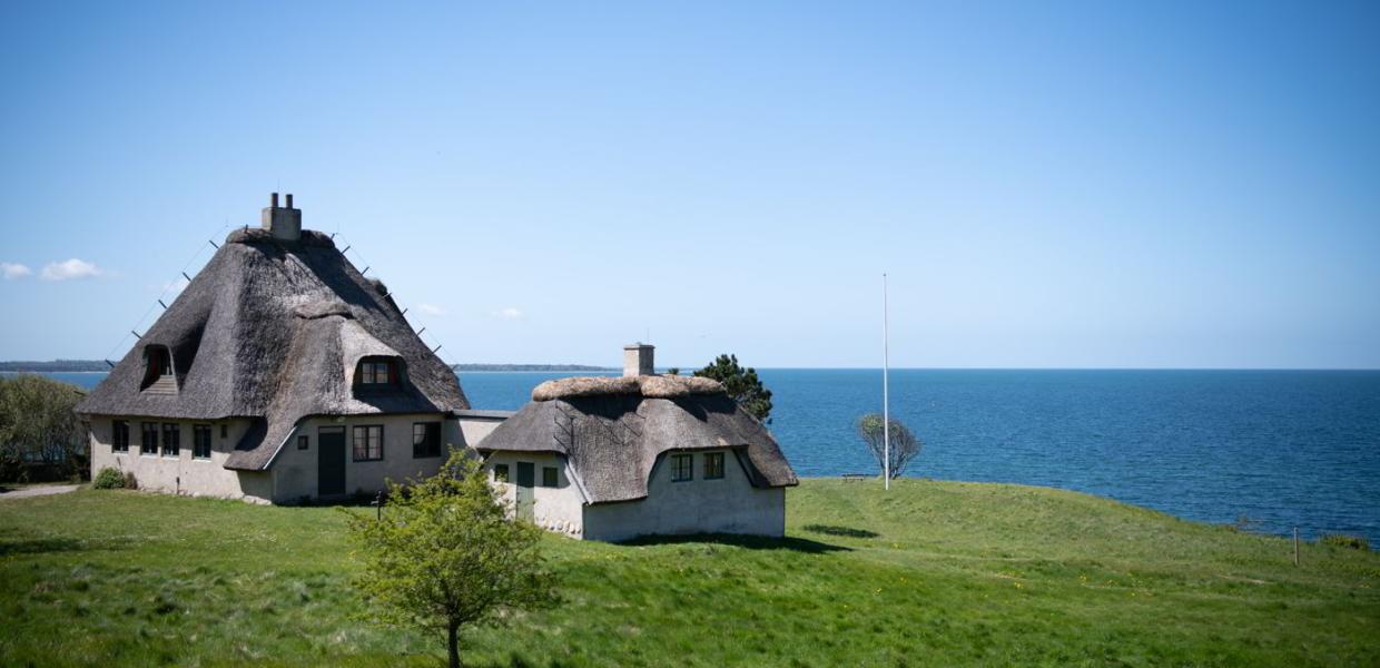 Knud Rasmussens Haus in Hundested steht bereit, Sie auf dem Hügel mit dem Meer im Hintergrund zu begrüßen.