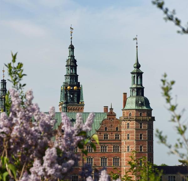 Frederiksborg Slot i forårssolen med syrener der blomstrer
